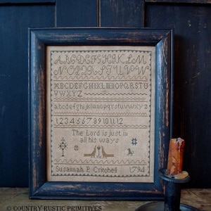 May include: A framed sampler with a black frame and a beige background. The sampler includes the alphabet, numbers, and the text "The Lord is just in all his ways". The sampler is signed "Susamah P. Critchell 1794".