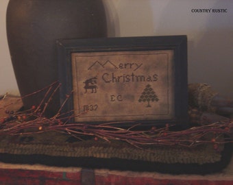 Puede incluir: Un sampler de punto de cruz enmarcado con el texto "Merry Christmas" y el año "1837". El sampler está en un marco de madera oscura y tiene un fondo marrón con puntadas negras. El sampler también incluye un árbol pequeño y un reno.