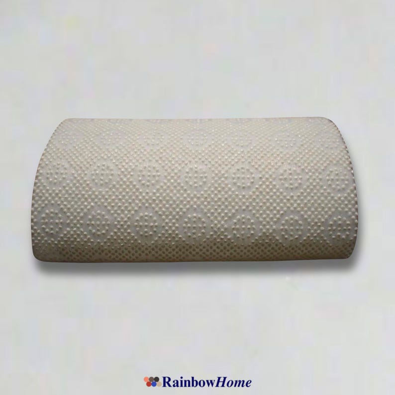 May include: A white, rectangular pillow with a raised, patterned surface. The pillow is slightly curved and has a soft, plush texture.