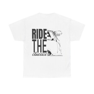 Può includere: T-shirt bianco con un'illustrazione in bianco e nero di un furgone classico. Il testo "RIDE THE classics" è stampato in nero, con "RIDE" e "THE" impilati verticalmente. Il furgone è raffigurato di profilo.