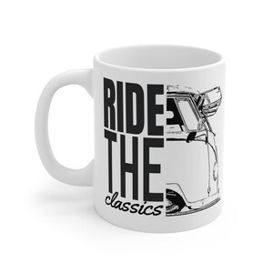 Può includere: Tazza in ceramica bianca con grafica nera di un furgone vintage e la scritta "RIDE THE classics". La tazza ha un manico curvo e una superficie liscia, ideale per caffè o tè.