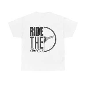 Può includere: T-shirt bianco con la scritta "RIDE THE classics" in nero. A destra del testo è presente una grafica di un volante nero e grigio. La maglietta è realizzata in un materiale morbido e confortevole.