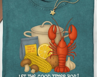 May include: Teal Comfort Colors t-shirt with a crawfish boil graphic. The design includes a red crawfish, vegetables, and the text "LET THE GOOD TIMES BOIL!". A gold necklace with a star pendant is also visible.