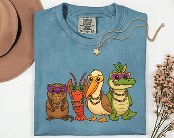 Camiseta unisex teñida en prenda de Louisiana Mardi Gras Kritter Krewe, con estampado de cocodrilo, cangrejo de río, nutria, pelícano, cuentas y máscaras.