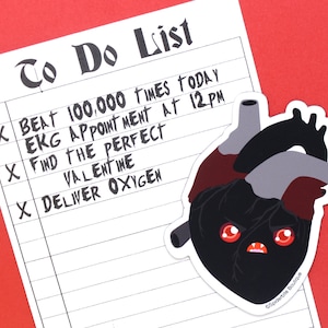 May include: A black and red heart with a grumpy face and the text "To Do List" with check marks next to the items: "Beat 100,000 times today", "EKG appointment at 12PM", "Find the perfect Valentine", and "Deliver oxygen".