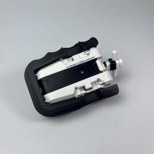 Puede incluir: Lanzador de cuerda Beyblade X blanco y negro con un mango negro. El lanzador tiene un mango blanco y una secci&oacute;n central negra. El texto "Beyblade X String Launcher" est&aacute; impreso en el lateral.