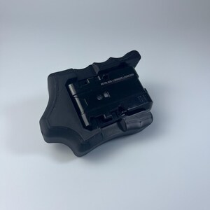 Puede incluir: Un lanzador negro Beyblade X Winder, un dispositivo port&aacute;til con un agarre texturizado. El lanzador tiene el texto "BEYBLADE X WINDER LAUNCHER" impreso en la parte superior. El dispositivo est&aacute; dise&ntilde;ado para lanzar peonzas Beyblade X.