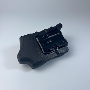 Puede incluir: Un lanzador de peonzas Beyblade X negro. El lanzador es negro con el texto "BEYBLADE X WINDER LAUNCHER" impreso en la parte superior. El lanzador est&aacute; dise&ntilde;ado para sujetarse con la mano y tiene un mecanismo de gatillo.