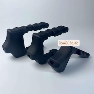 Puede incluir: Tres empu&ntilde;aduras negras para c&aacute;mara con agarre texturizado. Las empu&ntilde;aduras son de material mate y tienen un dise&ntilde;o curvo. El texto "Cooki3D Studio" es visible en la imagen.