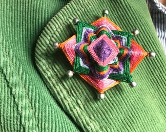 Mini 8-point godseye lapel pin handwoven from salvaged materials