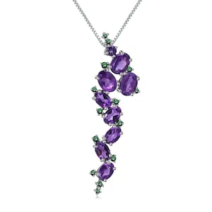 May include: A silver necklace with a pendant featuring a cluster of purple amethyst gemstones and smaller green gemstones.