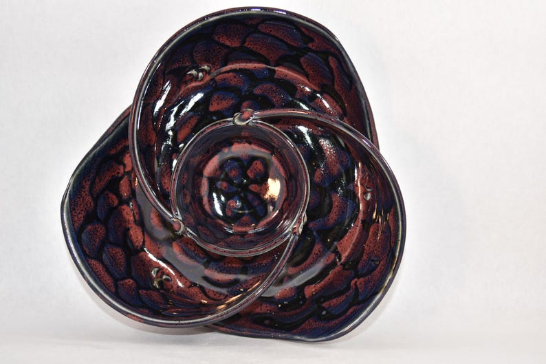 May include: A ceramic serving dish with three sections, each with a different swirling pattern of dark blue and burgundy glaze.
