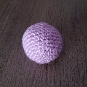 May include: A small, crocheted ball in a light purple color.