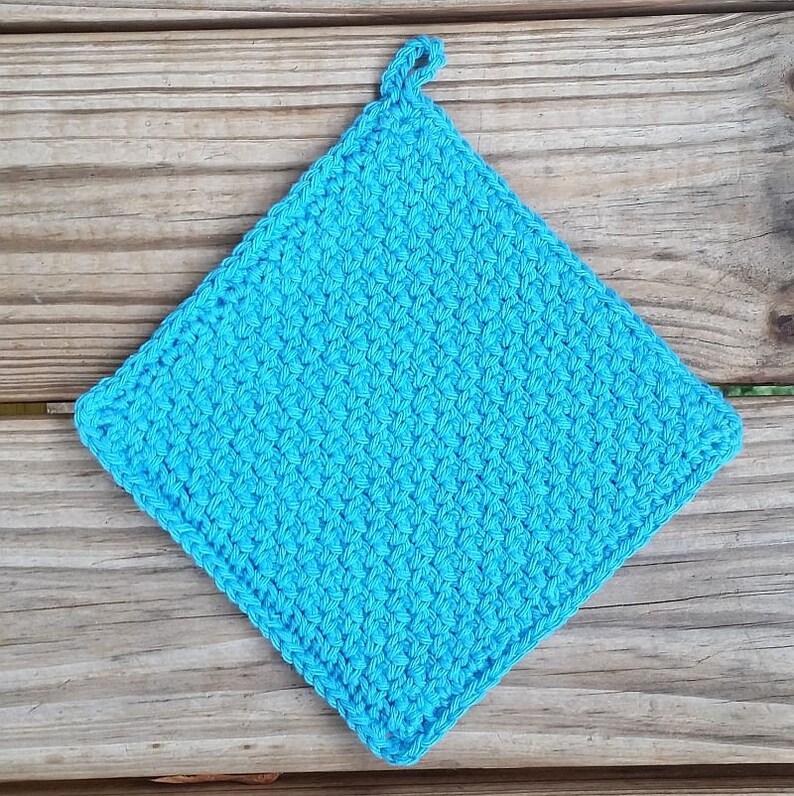 May include: A bright turquoise blue crocheted pot holder with a loop for hanging.