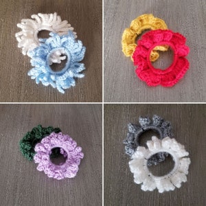 May include: Set of 10 crocheted hair scrunchies in various colors, including white, light blue, yellow, red, green, purple, gray, and white. The scrunchies are made with a soft, stretchy yarn and are perfect for holding hair in place.