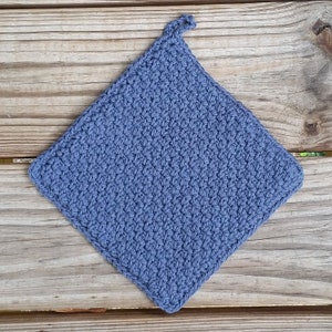 May include: A blue crocheted pot holder with a hanging loop. The pot holder is made with a simple stitch pattern.