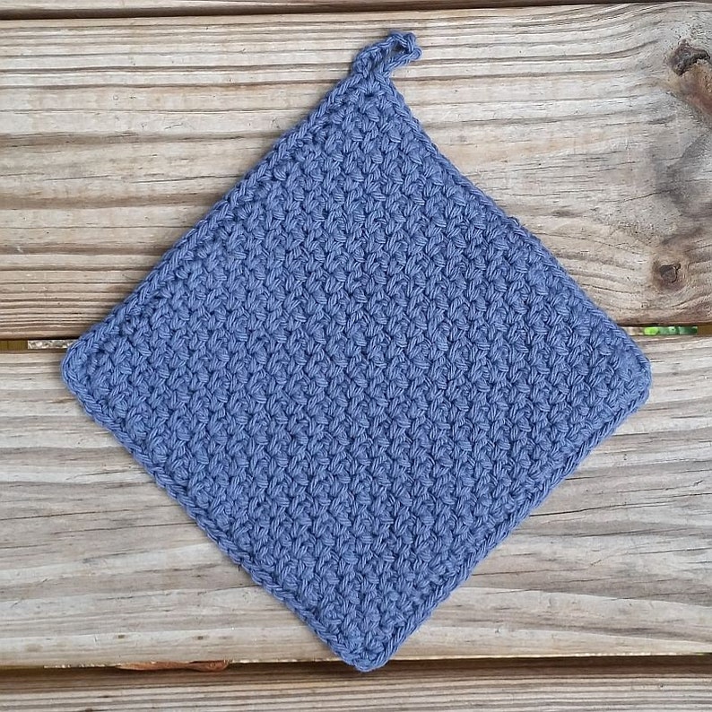 May include: A blue crocheted pot holder with a hanging loop. The pot holder is made with a simple stitch pattern.