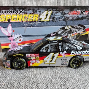 Op de afbeelding: Een zwarte 1/24 schaal diecast model auto van Jimmy Spencer's #41 Energizer Dodge. De auto heeft een roze Energizer konijnenlogo aan de zijkant en de woorden "Energizer" en "Coca-Cola" aan de achterkant.