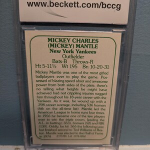 May include: A baseball card encased in a protective holder. The card features Mickey Mantle of the New York Yankees, an outfielder. The card includes his height of 5'11.5", weight of 195 lbs, and birthdate. The Beckett website is visible.