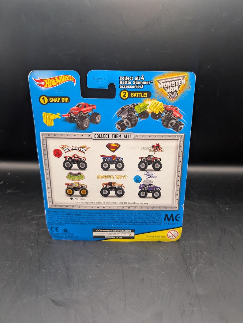 May include: A blue Hot Wheels Monster Jam toy package. The package features images of monster trucks, including "Destroyer" and "Monster Mutt." Text includes "Snap On!" and "Battle!" with the Monster Jam logo.