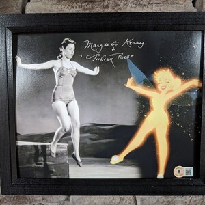 May include: A framed black and white photo of a woman jumping off a diving board with Tinkerbell from the Disney movie Peter Pan superimposed on the image. The photo is signed "Margaret & Kerry Tinkerbell Bell".