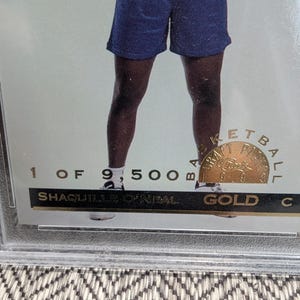 May include: Shaquille O'Neal basketball card. The card is gold and encased in a protective holder. The card is numbered 1 of 9,500. The card has a gold seal that says "Basketball" and "Classics".