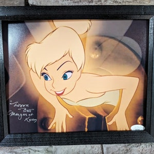 May include: A framed print of Tinkerbell from the Disney movie Peter Pan. The print is signed "Tinker Bell" by Margaret Kerry, the actress who provided the live-action reference for the animated character.