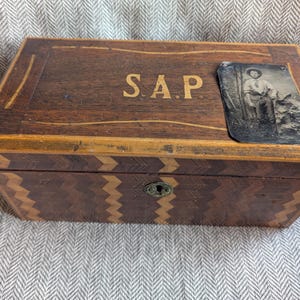 Caja de madera antigua de la época de la Guerra Civil con las iniciales de un soldado confederado identificado. Incluye una fotografía en TinType del soldado.