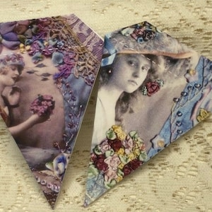 Puede incluir: Dos recortes de papel en forma de diamante con imágenes vintage. Uno presenta a una mujer sosteniendo flores, el otro a una mujer con sombrero. Ambos están adornados con adornos florales en tonos morados, azules y rosas, con delicados detalles de encaje.