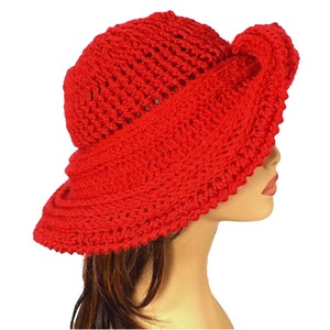 Red Mobius crochet hat with an intricate design, displaying the hat's profile with a twisted brim and full coverage on the mannequin's head