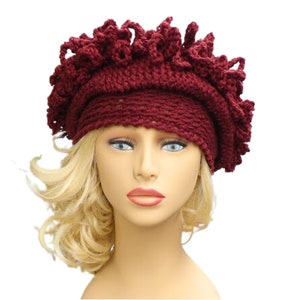 a mannequin head wearing a burgundy crocheted hat