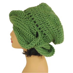 Unique Möbius Crochet Hat Pattern - Samantha Slouchy Beanie with Twist Brim. A green knit slouchy beanie hat modeled on a mannequin head, showing the side view. The hat has an unusual twisted, wrapped style to the brim.