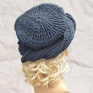 Back angle view of a mannequin head wearing a stylish navy Crochet Mobius hat with a distinctive Samantha slouchy design, set against a textured paper backdrop