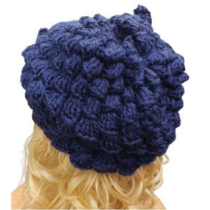 a mannequin head wearing a blue crocheted hat