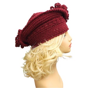 a mannequin head wearing a burgundy crocheted hat