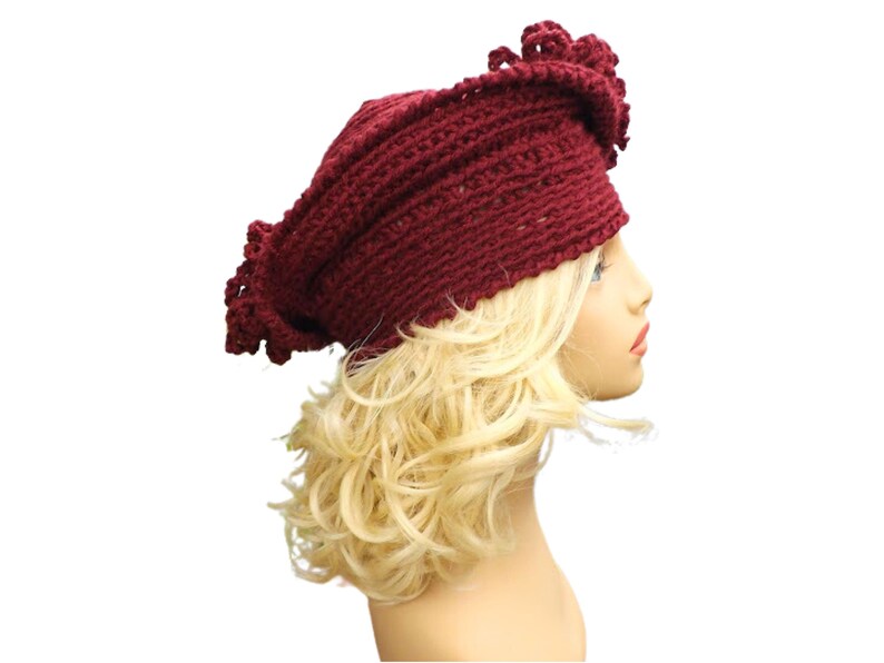 a mannequin head wearing a burgundy crocheted hat