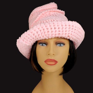 Angled front view of a pink Virginia Mobius strip crocheted cloche hat pattern on a mannequin, showcasing the unique twist and versatile design