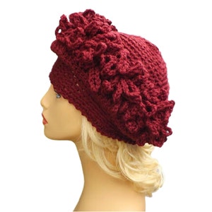 a mannequin head wearing a burgundy crocheted hat