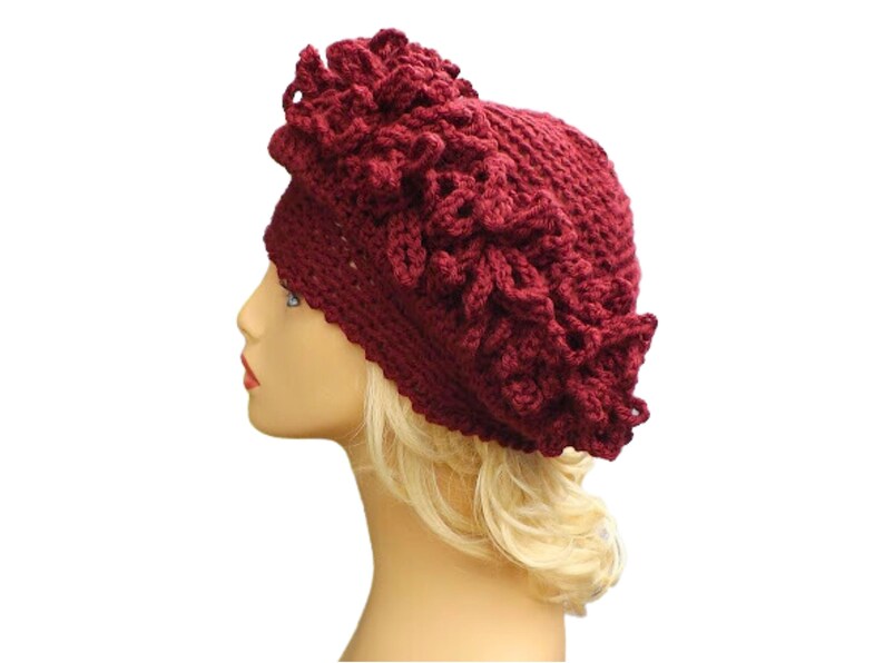 a mannequin head wearing a burgundy crocheted hat