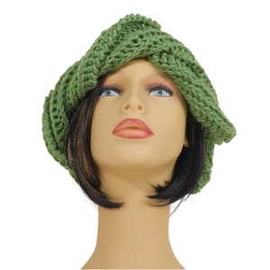 Unique Möbius Crochet Hat Pattern - Samantha Slouchy Beanie with Twist Brim. A side angle view of the green knit slouchy beanie hat on the mannequin head model, highlighting the unique wrapped and twisted style of the brim.