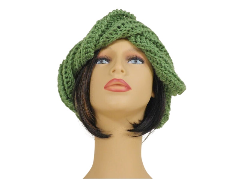 Unique Möbius Crochet Hat Pattern - Samantha Slouchy Beanie with Twist Brim. A side angle view of the green knit slouchy beanie hat on the mannequin head model, highlighting the unique wrapped and twisted style of the brim.
