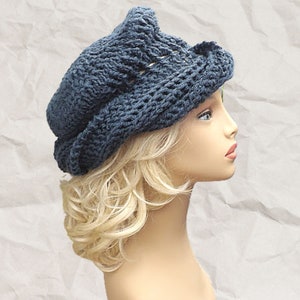 Profile view of a navy blue Crochet Mobius Samantha slouchy hat pattern with an avant-garde twisted brim on a mannequin, emphasizing a modern twist on women's fashion accessories