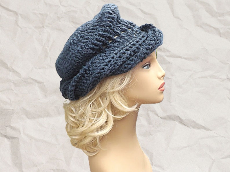 Profile view of a navy blue Crochet Mobius Samantha slouchy hat pattern with an avant-garde twisted brim on a mannequin, emphasizing a modern twist on women's fashion accessories