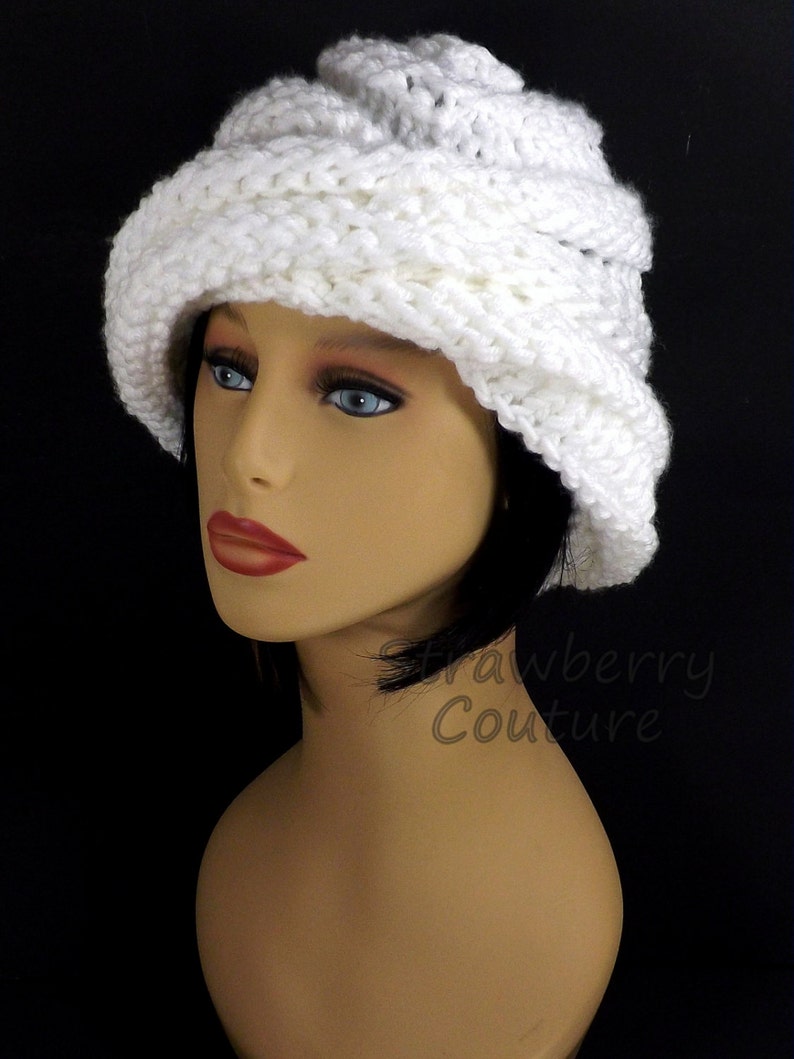 Close-up side view of a white Ombretta chemo cloche hat on a mannequin, emphasizing the intricate knitting pattern and the elegant Mobius design