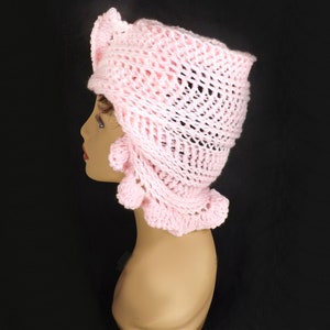 a crocheted hat with a ruffle on a mannequin head