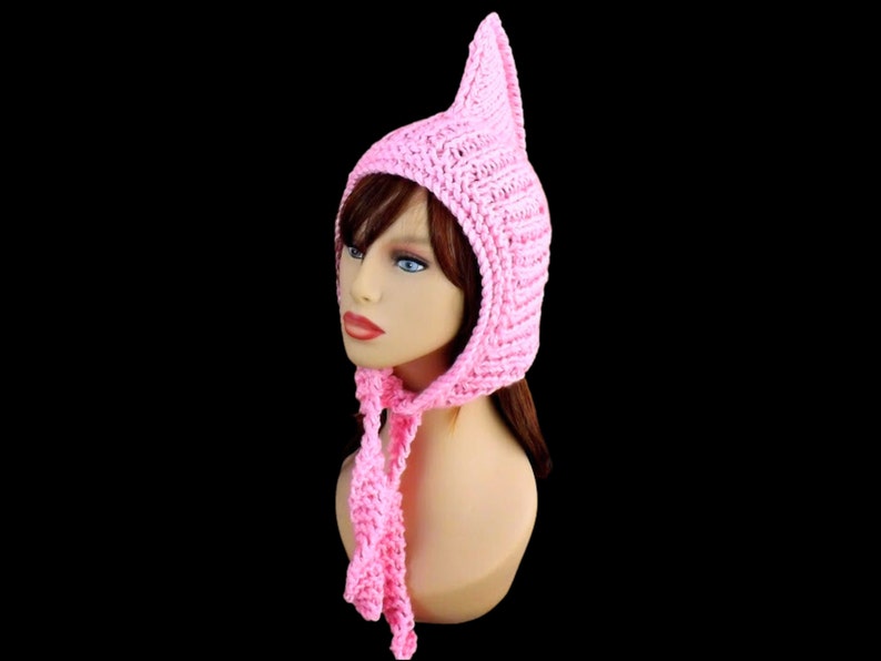 a pink knitted pixie hood hat on a mannequin head