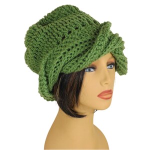 Unique Möbius Crochet Hat Pattern - Samantha Slouchy Beanie with Twist Brim. The green knit slouchy beanie hat with wrapped brim modeled on the mannequin head, viewed in profile from the opposite side compared to Image 1.