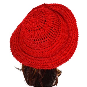 Another angle of the red Mobius crochet hat from the side, accentuating the hat's dimensional brim and elegant twist