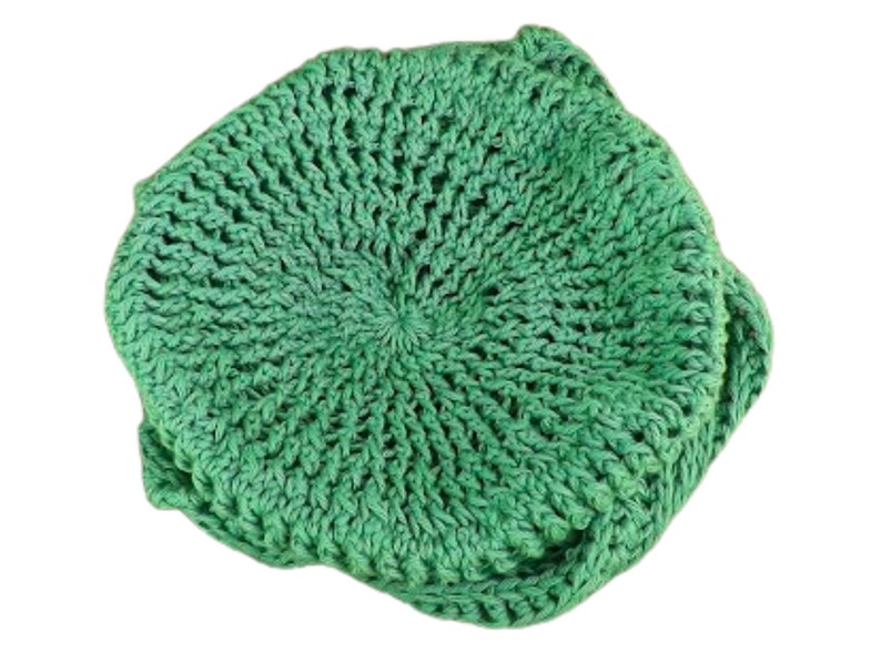 Unique Möbius Crochet Hat Pattern - Samantha Slouchy Beanie with Twist Brim. Top-down view of a handmade green crochet hat with a swirled, twisted pattern resembling a mobius strip. The hat has a slouchy, oversized fit.