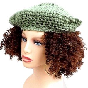 a mannequin head wearing a green crochet hat